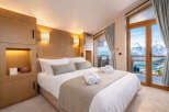 Experience luxury living in this stunning bedroom with breathtaking mountain views.