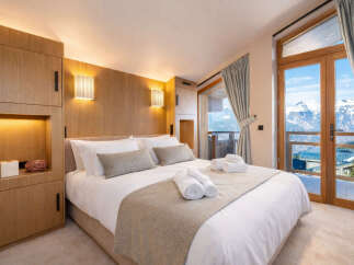 Experience luxury living in this stunning bedroom with breathtaking mountain views.