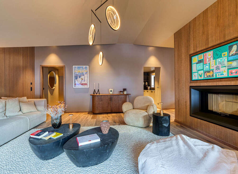 Experience luxury living in this stunning property, featuring a cozy living room with a modern fireplace and a stylish seating area.