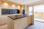 This stunning kitchen boasts a modern design with natural wood cabinetry and a sleek black countertop.