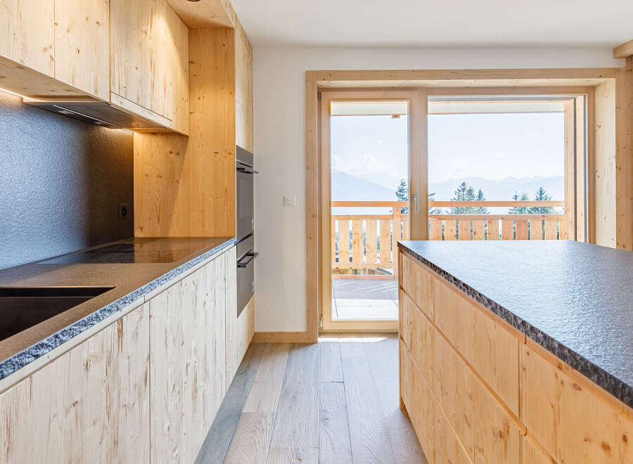 Experience the warmth of this stunning kitchen, featuring custom wood cabinetry and sleek countertops.