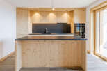 This stunning kitchen boasts a modern design with natural wood cabinetry and a sleek black countertop.
