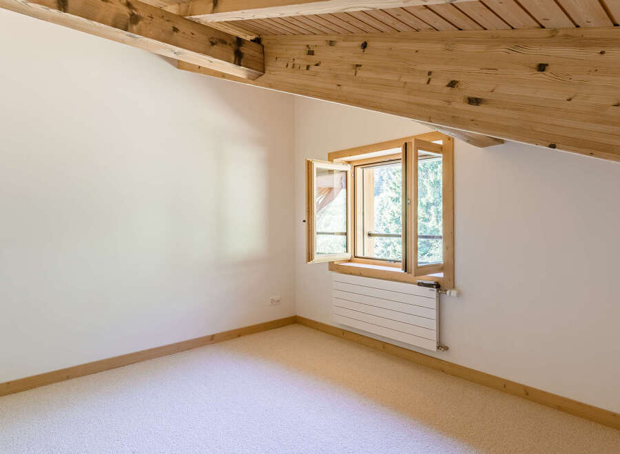 Discover the charm of this cozy attic room, featuring a unique window design that invites natural light.