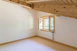 Discover the charm of this cozy attic room, featuring a unique window design that invites natural light.