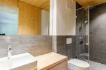 This modern bathroom features a sleek design with a wooden vanity and a stylish sink.