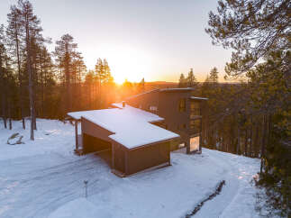 Experience the tranquility of this stunning modern home nestled in a snowy landscape.