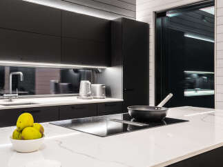 Modern kitchen design with sleek black cabinetry and a contrasting white countertop.