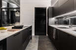 This modern kitchen boasts sleek black cabinetry and a pristine white countertop, creating a sophisticated and stylish space.