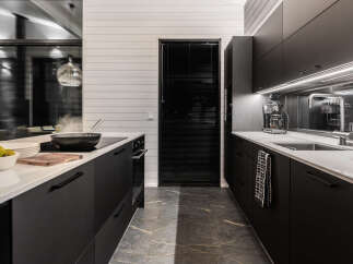 This modern kitchen boasts sleek black cabinetry and a pristine white countertop, creating a sophisticated and stylish space.