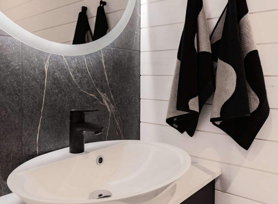 Modern bathroom design featuring a sleek black faucet and a stylish white sink.