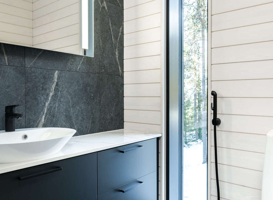 This modern bathroom boasts a sleek design with dark cabinetry and a stylish sink.