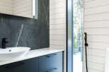 This modern bathroom boasts a sleek design with dark cabinetry and a stylish sink.