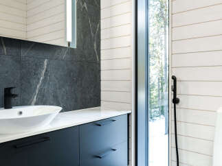 This modern bathroom boasts a sleek design with dark cabinetry and a stylish sink.