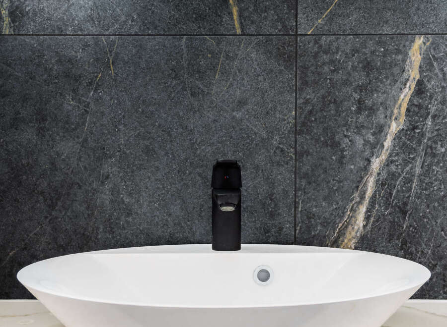 Modern bathroom design featuring a sleek white oval sink and a stylish black faucet.