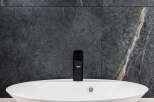 Modern bathroom design featuring a sleek white oval sink and a stylish black faucet.