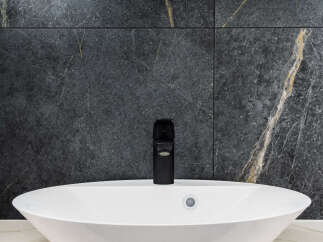 Modern bathroom design featuring a sleek white oval sink and a stylish black faucet.