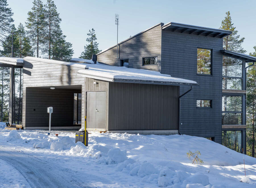 This modern home boasts a striking design with its dark gray exterior and unique architectural features.