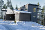 This modern home boasts a striking design with its dark gray exterior and unique architectural features.