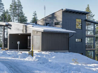 This modern home boasts a striking design with its dark gray exterior and unique architectural features.