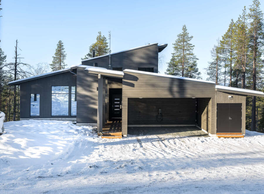 This modern home boasts a sleek, dark exterior and a unique architectural design.