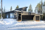This modern home boasts a sleek, dark exterior and a unique architectural design.