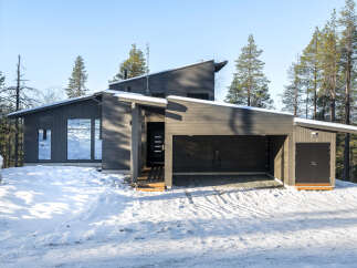 This modern home boasts a sleek, dark exterior and a unique architectural design.