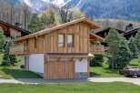 Stunning chalet in the mountains with a spacious wooden exterior and large windows.