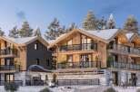 Luxury chalet-style apartments in the French Alps, boasting stunning mountain views and spacious balconies.
