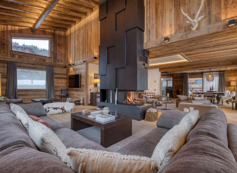 Experience luxury living in this stunning chalet, featuring a grand fireplace and exquisite wooden accents throughout.