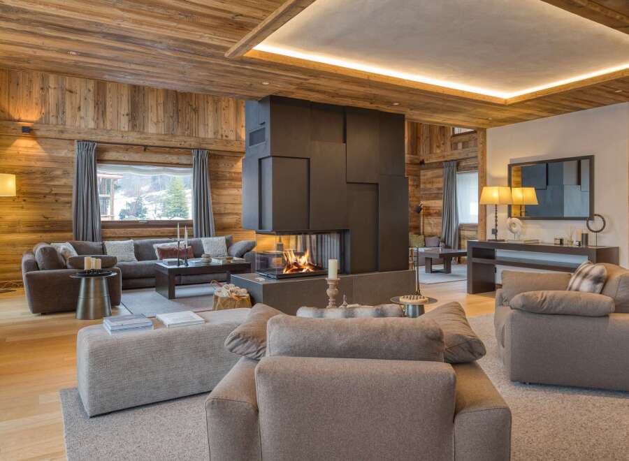 Experience luxury living in this stunning chalet, featuring a cozy fireplace and elegant wooden accents.