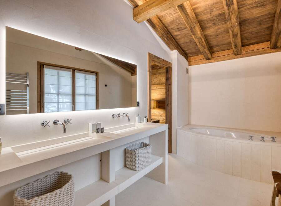 This luxurious bathroom features a stunning wooden ceiling and a spacious vanity with double sinks.