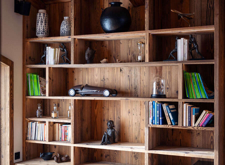 This stunning property boasts a custom-built wooden bookshelf, adding a touch of rustic elegance to the space.