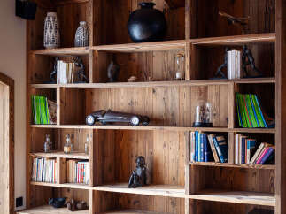 This stunning property boasts a custom-built wooden bookshelf, adding a touch of rustic elegance to the space.