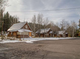 Rustic wooden cabins nestled in a snowy forest setting, offering a charming and peaceful getaway.