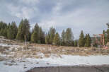 This property boasts a stunning mountain view, with a snow-dusted landscape and a backdrop of tall evergreen trees.