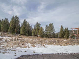 This property boasts a stunning mountain view, with a snow-dusted landscape and a backdrop of tall evergreen trees.