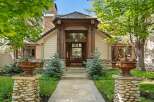 This stunning home boasts a charming stone and wood exterior, complemented by lush landscaping and meticulously placed stonework.