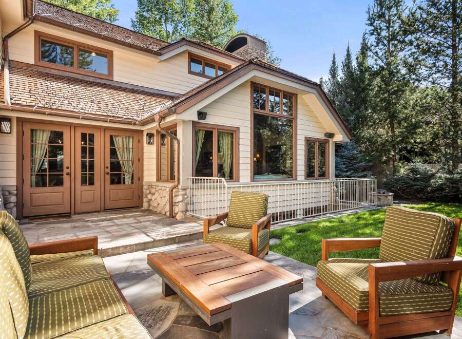 This stunning home boasts a spacious patio with comfortable outdoor furniture, perfect for relaxing and enjoying the beautiful landscaping.