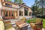 This stunning home boasts a spacious patio with comfortable outdoor furniture, perfect for relaxing and enjoying the beautiful landscaping.