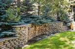 This serene backyard oasis features a stunning stone waterfall, creating a tranquil ambiance.