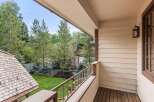 This charming balcony boasts a picturesque view of a lush green lawn and mature trees, creating a serene and private outdoor space.