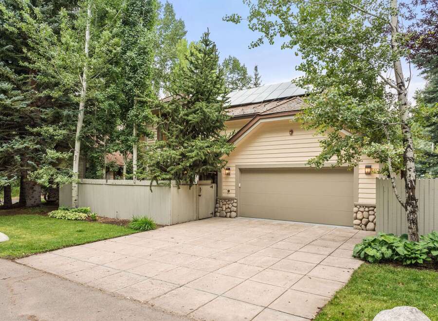This charming home boasts a spacious driveway, a large garage, and a well-maintained lawn.