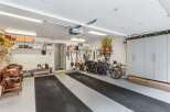 This spacious garage boasts ample storage solutions, including overhead shelving, wall cabinets, and floor-to-ceiling storage units.