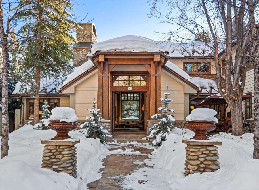 This stunning mountain home boasts a charming stone and wood exterior, perfectly complementing its snowy surroundings.