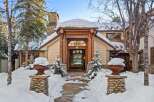 This stunning mountain home boasts a charming stone and wood exterior, perfectly complementing its snowy surroundings.