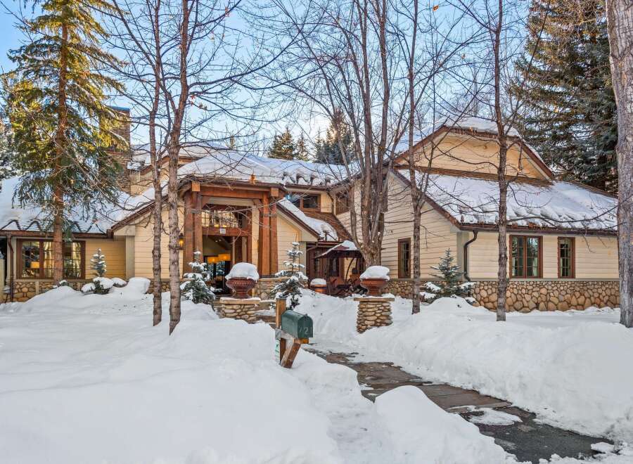 This stunning mountain home boasts a charming exterior with a mix of wood and stone, creating a cozy and inviting atmosphere.