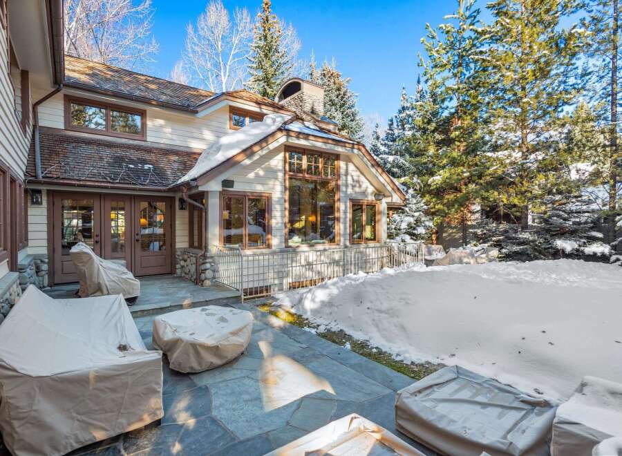 This stunning property boasts a spacious patio perfect for outdoor entertaining, complete with a stone fire pit and comfortable seating areas.
