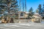 This stunning winter home boasts a charming exterior with a large attached garage and a fenced yard.