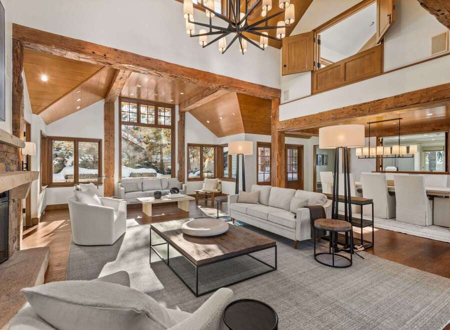 This stunning property boasts a spacious, open-plan living area with soaring ceilings and exposed wooden beams, creating a warm and inviting atmosphere.