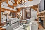 This stunning living room boasts a double-height ceiling with exposed wooden beams, creating an open and airy atmosphere.